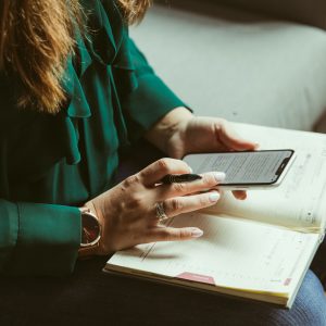 person-browsing-smartphone-over-open-book