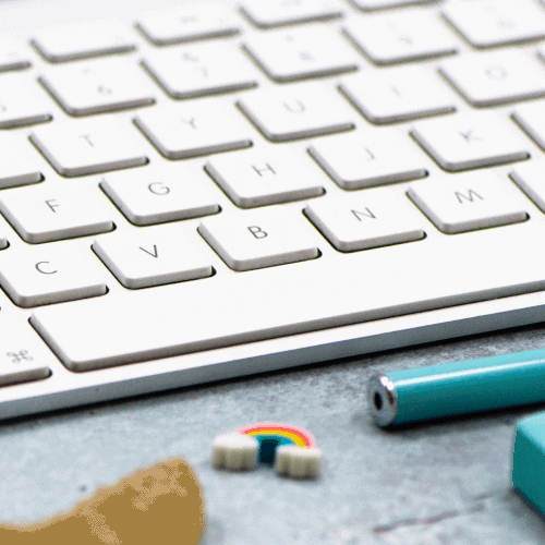 mac-keyboard-on-shiny-background-with-rainbow-eraser-shell-and-blue-pencil