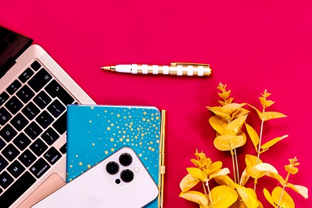 flatlay-iphone-blue-gold-star-notebook-laptop-yellow-leaves-bright-pink-background
